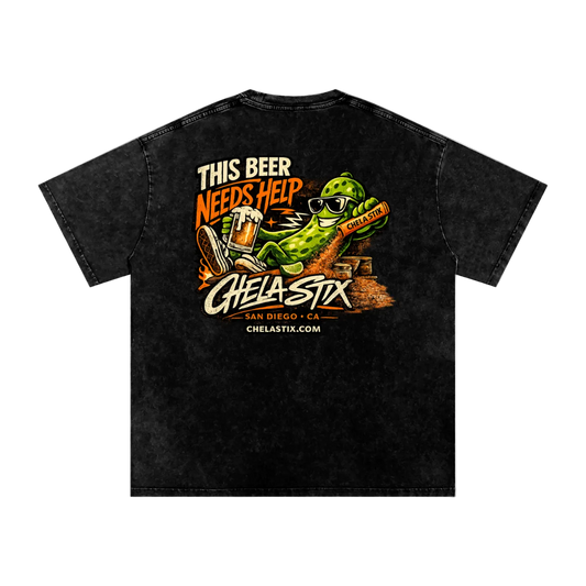 A black acid-wash t-shirt shown from the back, featuring a large graphic print of a green alligator wearing sunglasses and holding a beer mug, with the text 'THIS BEER NEEDS HELP' and 'CHELA-STX'.