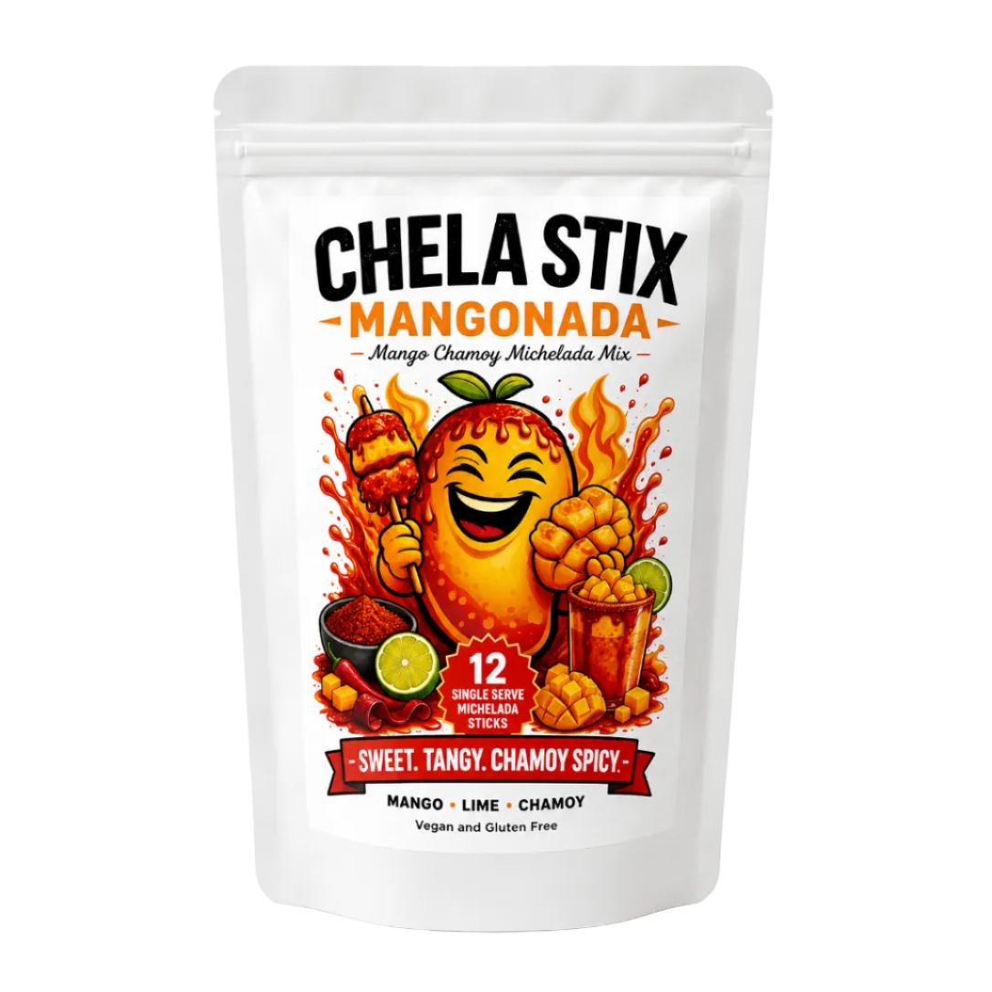 A white stand-up pouch of Chela Stix Mangonada (mango chamoy chili stick mix) featuring a colorful cartoon illustration of a smiling mango holding a chili skewer, with flames and lime slices.